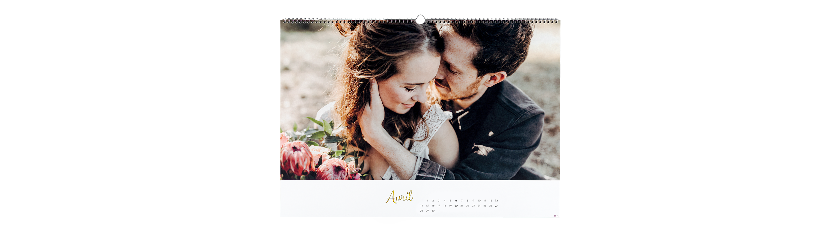 Page de calendrier avec un couple romantique dans la nature, entouré de fleurs colorées.