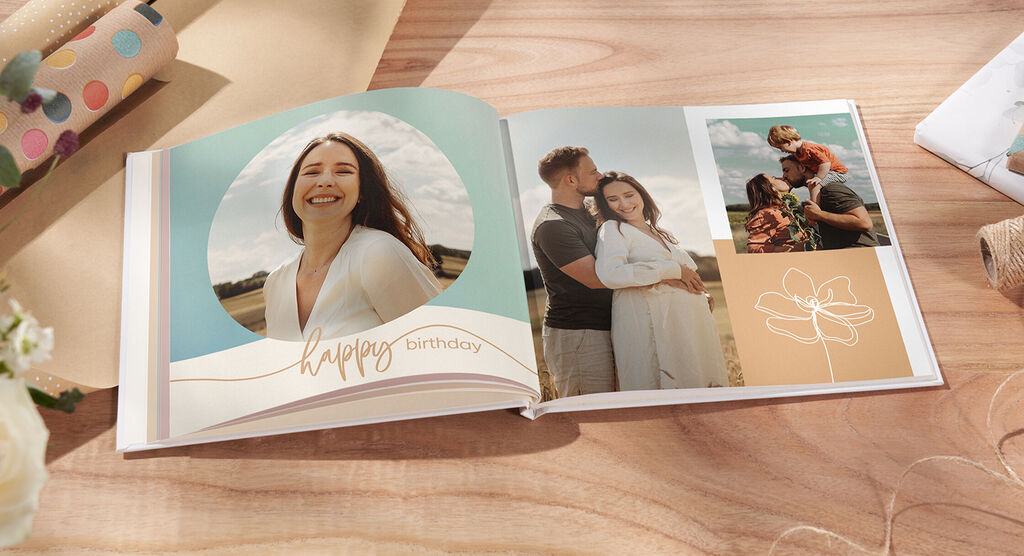 Un livre photo ouvert avec deux images affectueuses, un message d'anniversaire et un design floral.