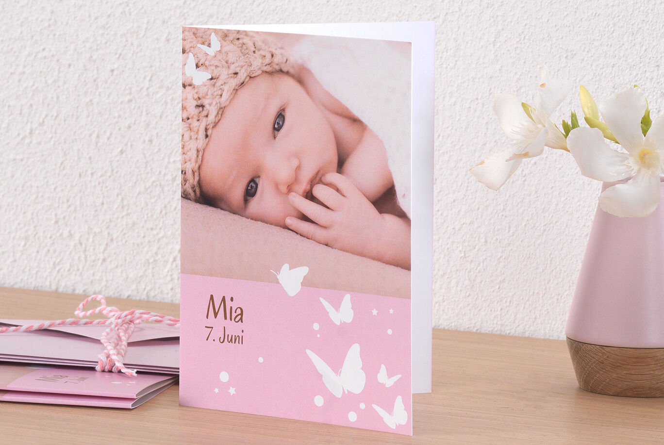 Une carte de vœux joyeuse et personnalisée avec des papillons en rose pastel, conçue pour Mia.