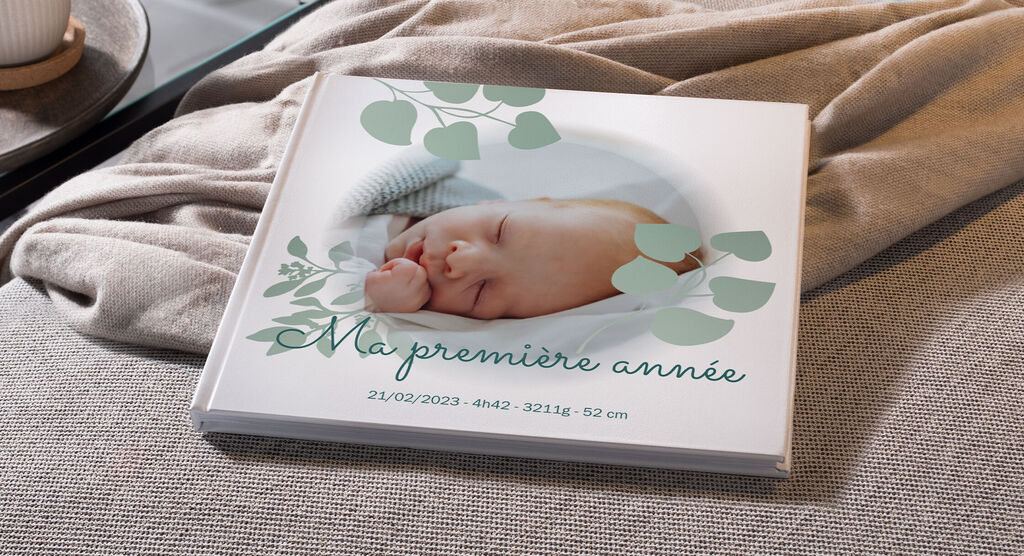 Un CEWE PHOTOBOOK tendre avec le titre "Ma première année" et une photo de bébé en couverture.