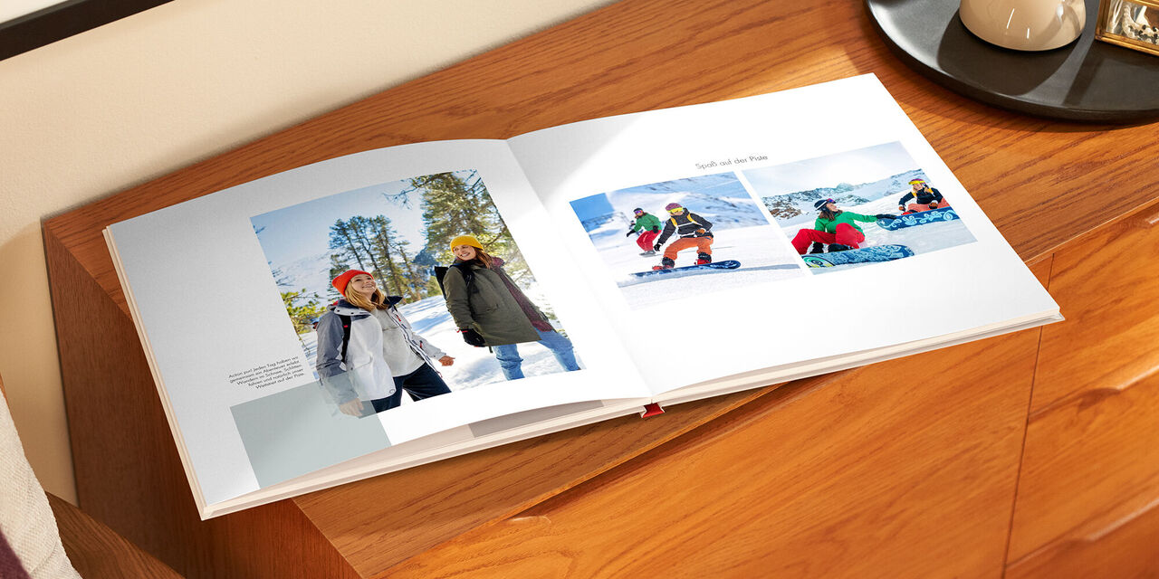 Le livre de photos ouvert est posé sur une armoire en bois. À gauche, on voit une photo de deux femmes en randonnée. À côté, se trouve un petit bloc de texte. Sur la page de droite, on voit deux photos de femmes faisant du snowboard. Au-dessus, on peut lire le titre « Le plaisir sur les pistes ».