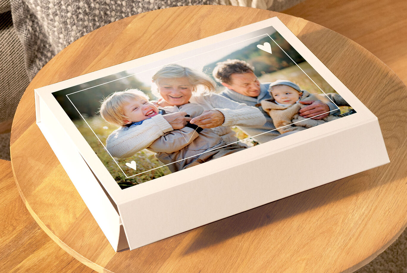 Une famille aimante regardant un album photo CEWE sur une surface en bois confortable