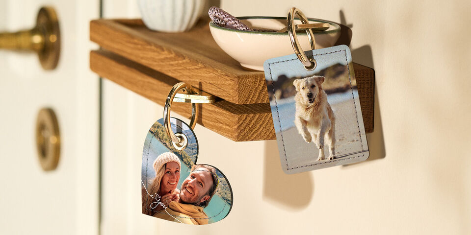 Deux porte-clés en forme de cœur et rectangulaire avec une photo d'un chien et une personne tenant un cœur.
