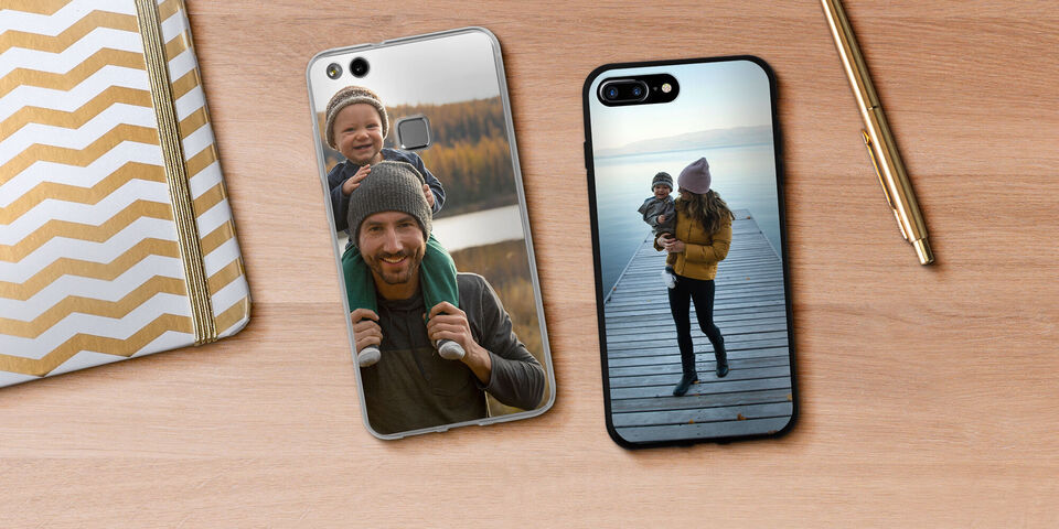Deux téléphones avec différentes coques photo sur une table en bois, l'un montre une image dans la nature, l'autre une femme avec un enfant au bord de l'eau.