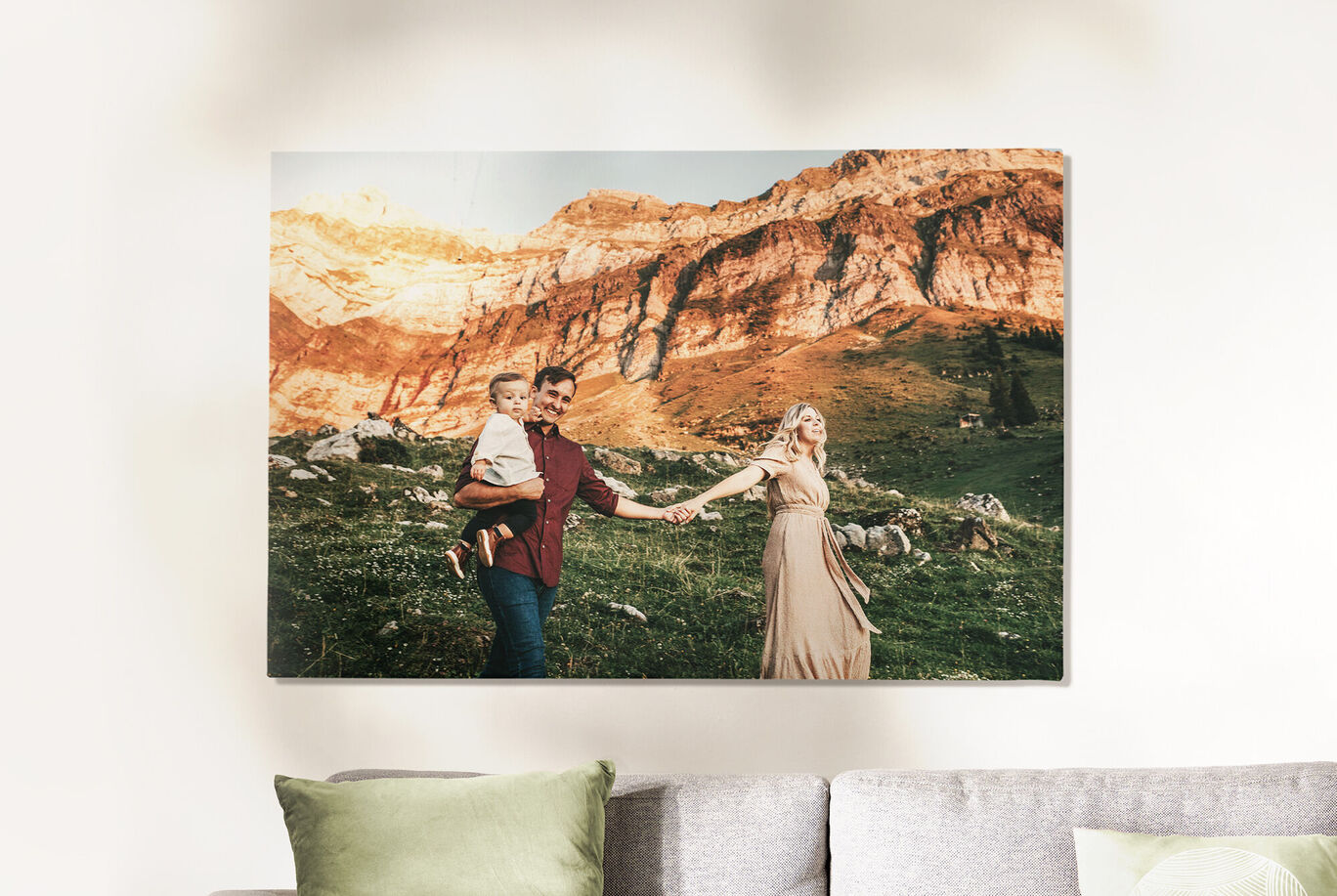 Une famille avec un enfant se tient par la main en se promenant dans un paysage de montagnes vertes.