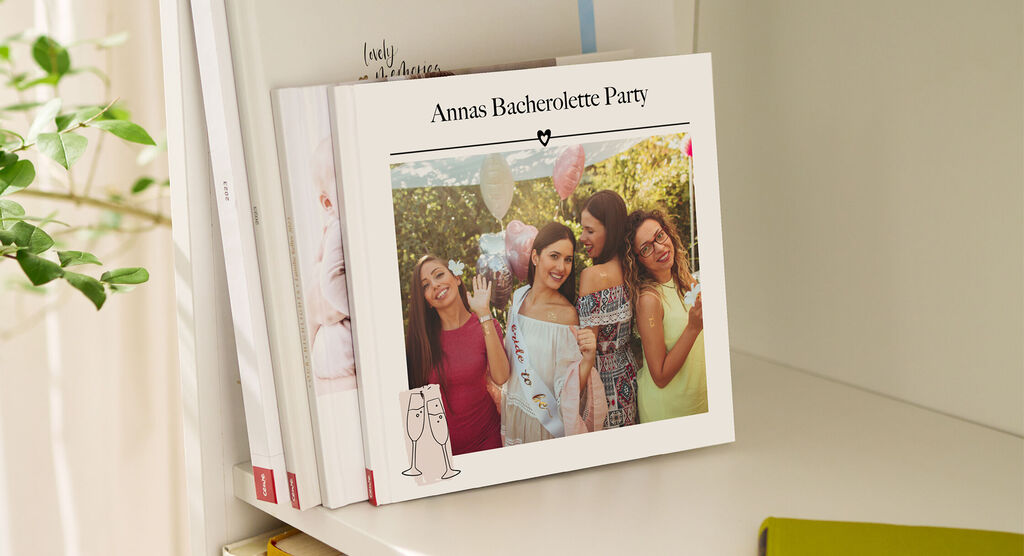Un album photo CEWE de l'enterrement de vie de jeune fille d'Anna, avec la fête en plein air et des femmes festives en couverture.