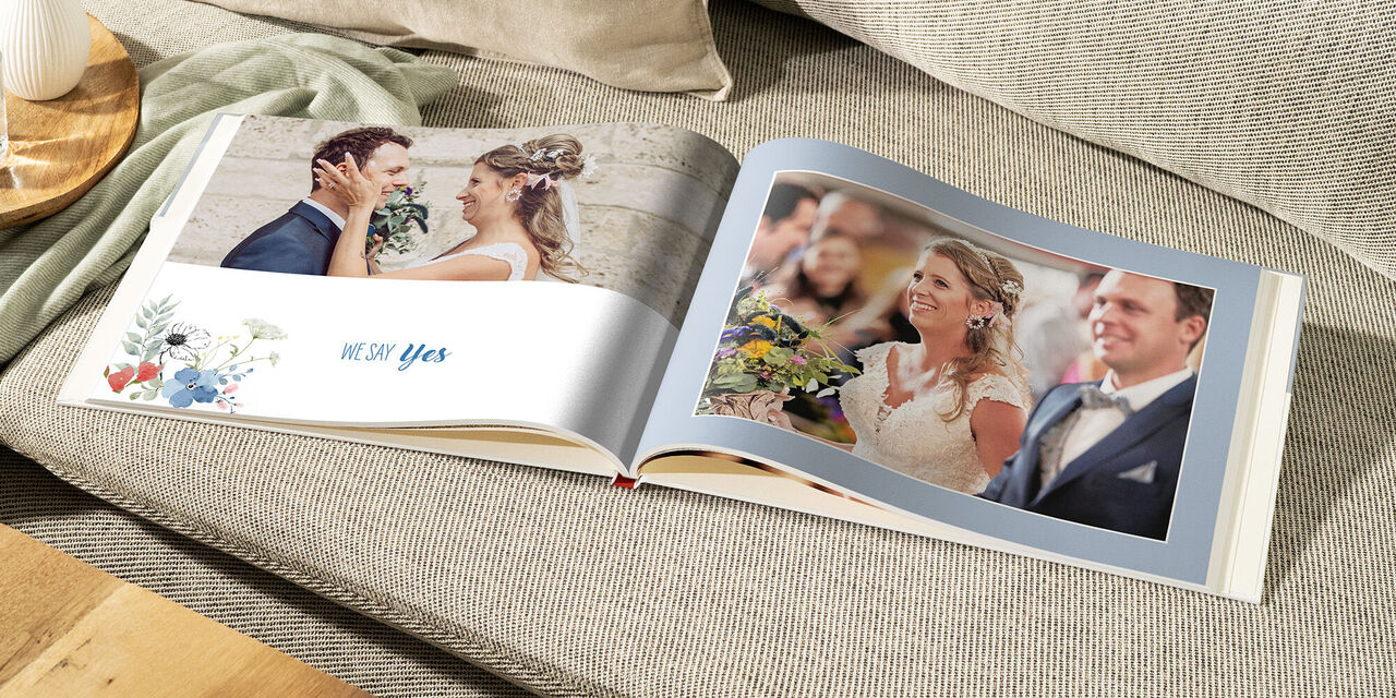 Un livre photo ouvert sur un canapé confortable montre un mariage romantique, avec de beaux souvenirs.
