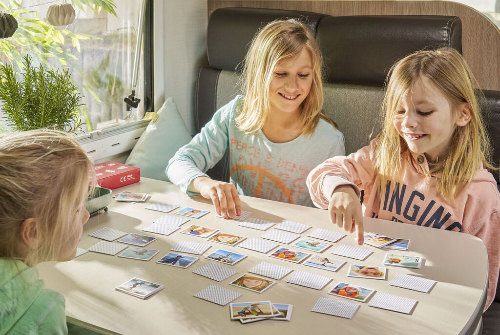 Des enfants jouent à un jeu de mémoire avec des images de leurs moments préférés