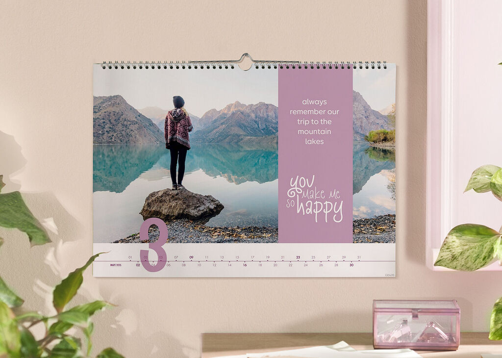 Une femme devant un lac de montagne, regardant un calendrier.