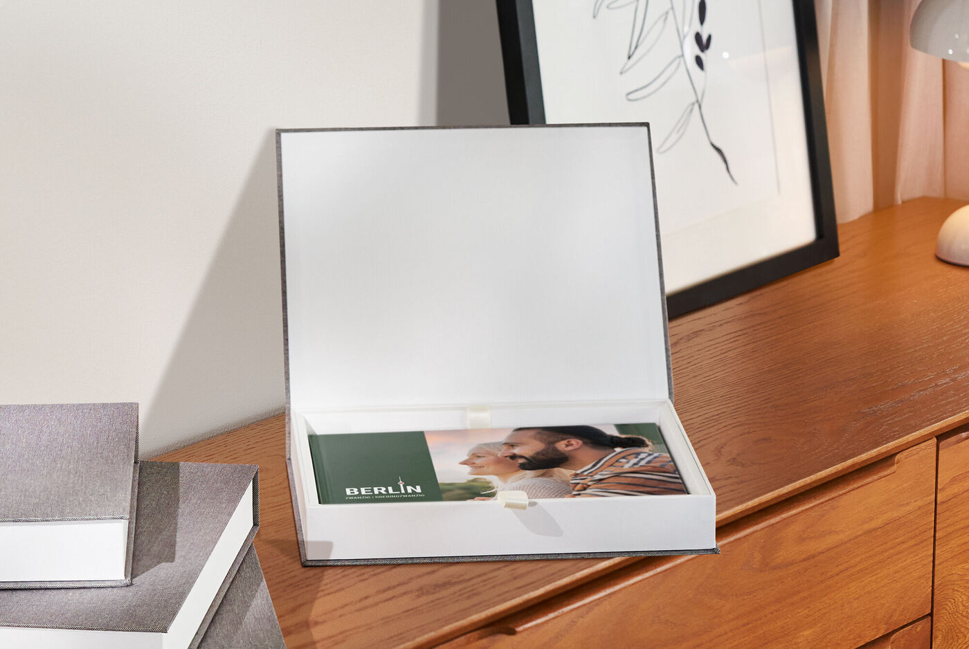 Beau CEWE Album Photo dans une boîte cadeau ouverte sur une table en bois